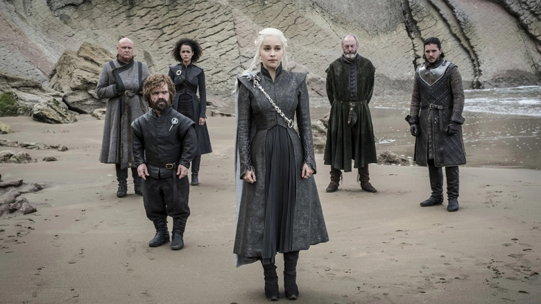 Daenerys, Tyrion, Varys, Missandei, Davos and Jon standing on a beach posing like a bad album cover in Game of Thrones