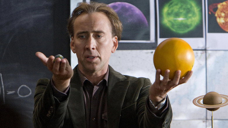 John Koestler holding a model Earth and a model Sun in Knowing