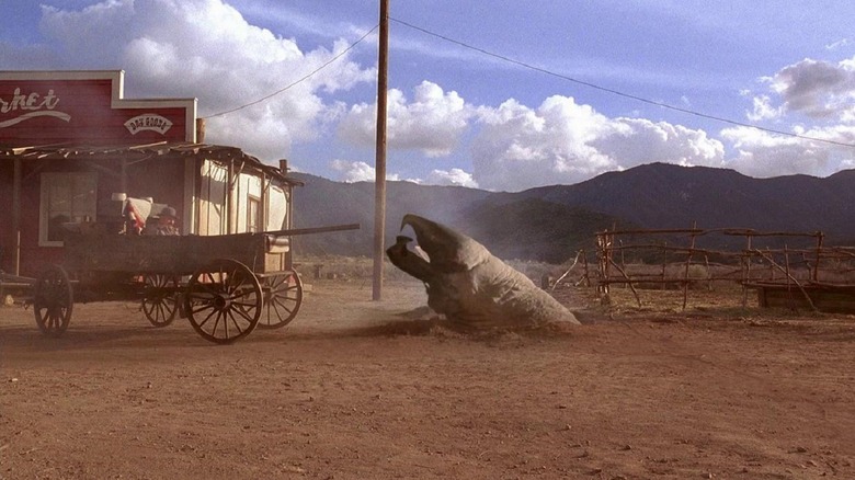 A graboid reaching out of the ground in front of a wagon in Tremos 4: The Legend Begins