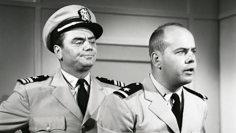 Ernest Borgnine as Lt. Cmdr. Quinton McHale looks disapprovingly over the shoulder of Tim Conway as Ensign Charles Parker in McHale's Navy