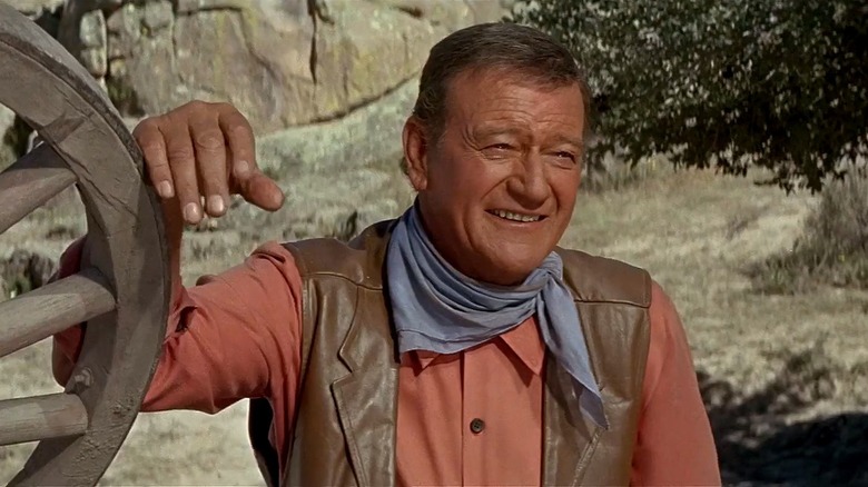 Taw Jackson (John Wayne) leaning on a wheel in "The War Wagon"