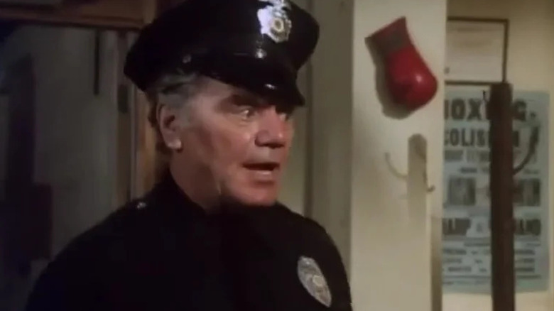 Joe Cleaver (Ernest Borgnine) stands in a police uniform at the gym in Future Cop