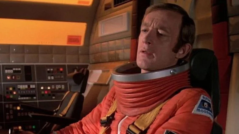 Alan Carter (Nick Tate) sits in a cockpit wearing a spacesuit in Space: 1999