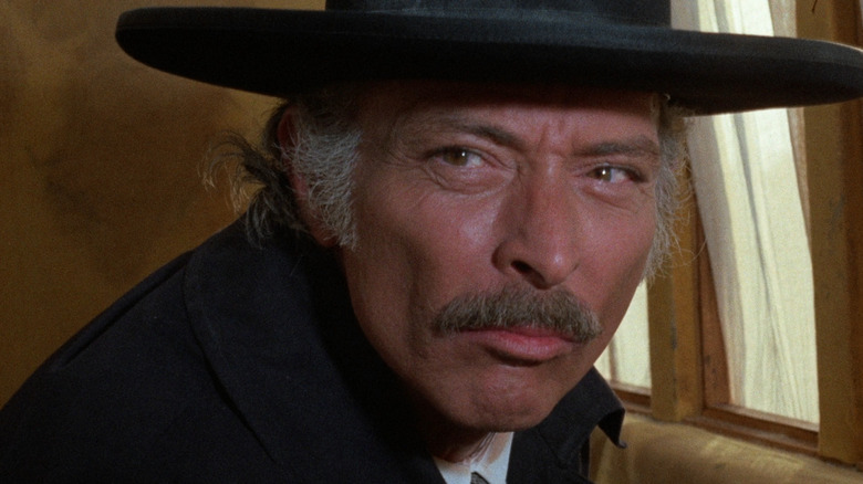 Sheriff Clayton crouching next to a window in "The Grand Duel"