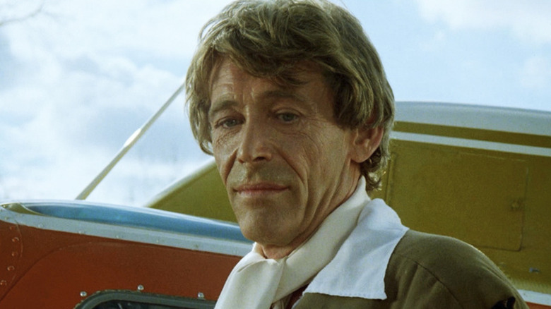 Peter O'Toole stands next to an airplane as Eli Cross in The Stunt Man