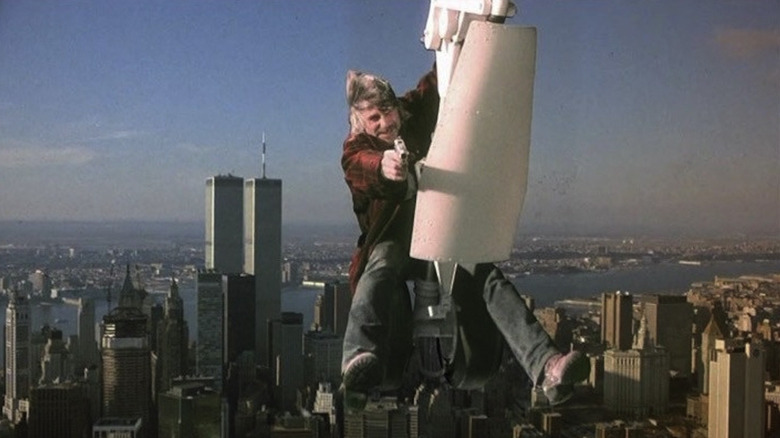 Sam Elliott brandishes a gun while hanging from the landing gear of a plane flying over Manhattan in Stakeout