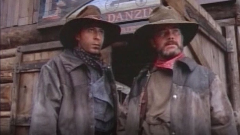 Jack Craddock (Richard Comar) and Clive Bennett (John H. Brennan) stand in front of a saloon in Bordertown (1989)