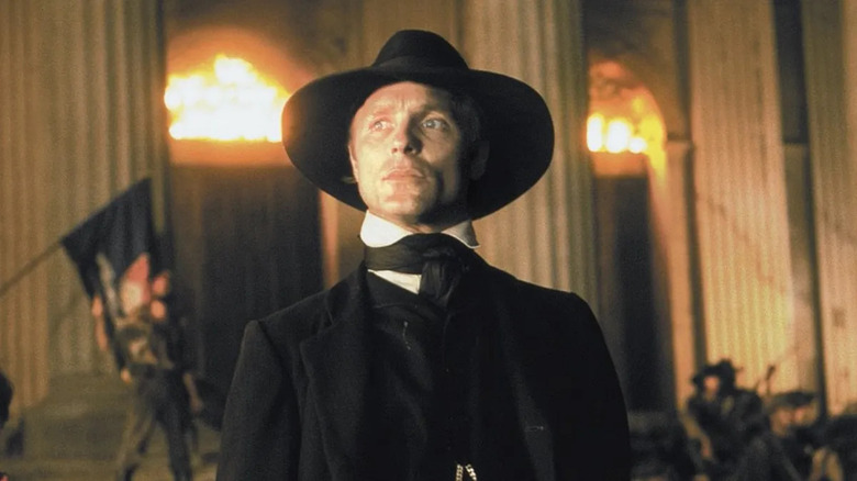 William Walker (Ed Harris) standing in front of a building in "Walker"