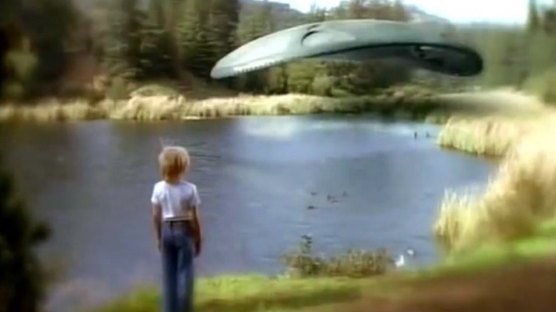 A boy looking at an alien space craft over a lake in Intruders
