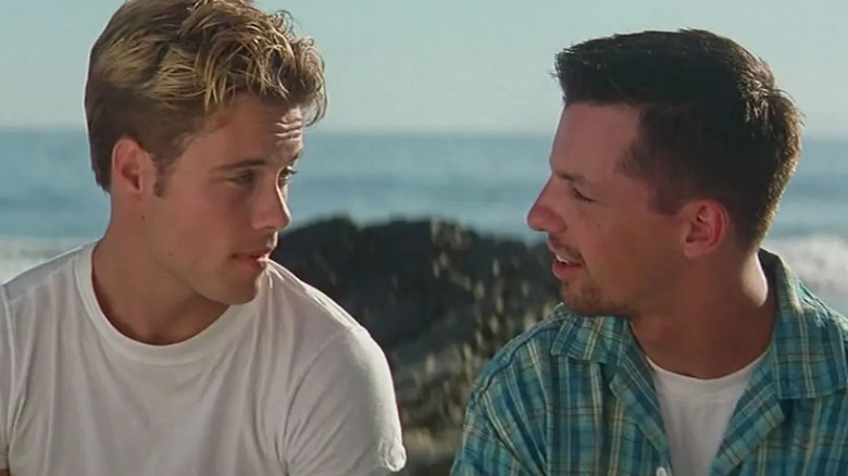 Gabriel and Billy sitting on a beach in Billy's Hollywood Screen Kiss
