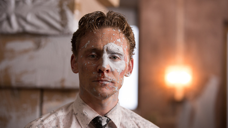 Robert Laing with his face covered in paint in High-Rise