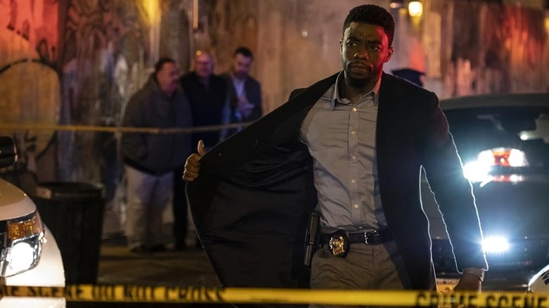 Chadwick Boseman as Andre Davis walking up to police tape in 21 Bridges