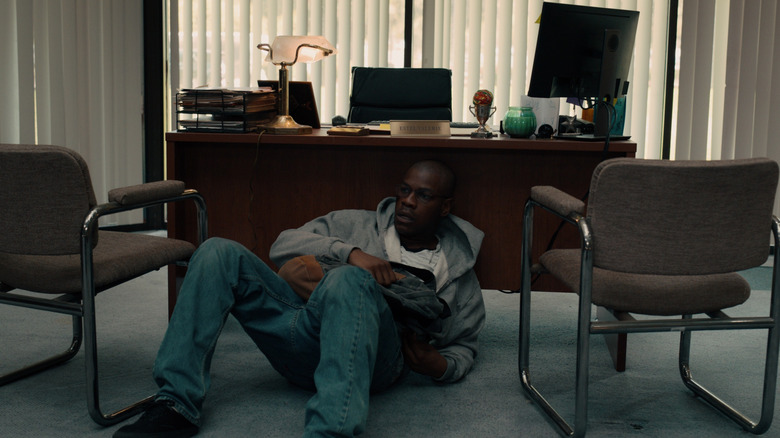 John Boyega as Brian Brown-Easley huddled by a desk in Breaking