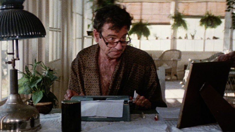 Miles Kendig with an open robe at a typewriter in Hotscotch
