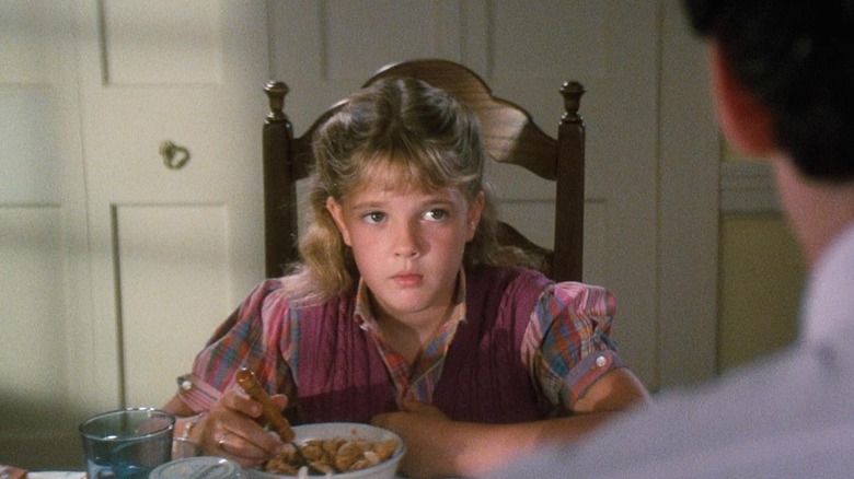 Amanda sitting at a table with a bowl of cereal in Cat's Eye