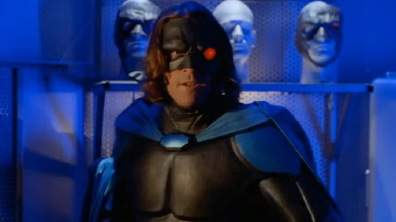 The Night Man in front of three mannequin heads in Night Man