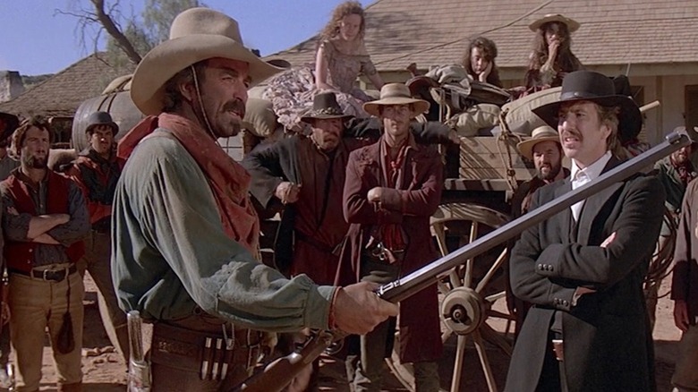 Tom Selleck as Matthew Quigley shows off his rifle to Alan Rickman as Elliott Marston in Quigley Down Under