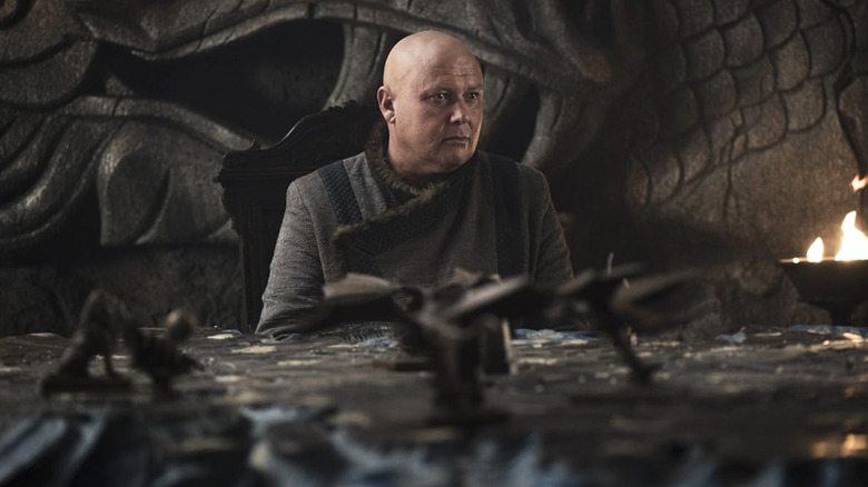 Game of Thrones, Varys seated at a table, looking at someone off screen