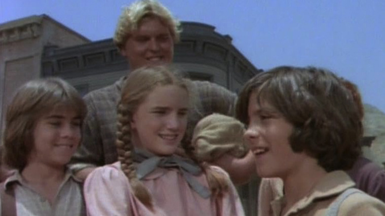 A bunch of Ingalls family members standing around outside in Little House on the Prairie