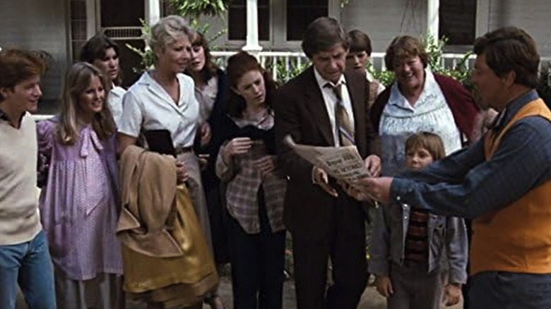 The Waltons gathering around a person with a newspaper