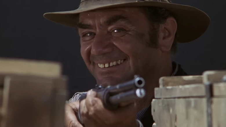 Ernest Borgnine's "Dutch" Engstrom smiles as he aims a rifle in The Wild Bunch