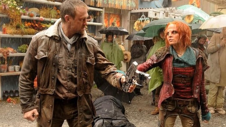 Irisa grabbing Joshua's hand in a rainy marketplace in Defiance