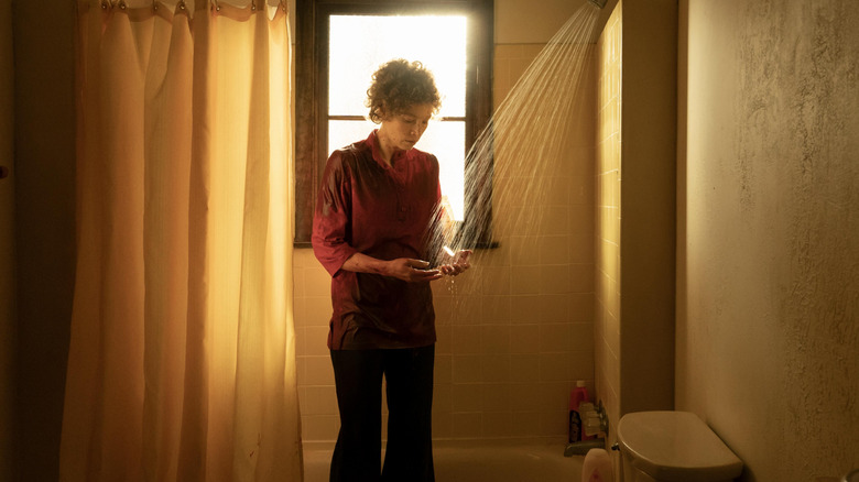 Candy standing fully clothed in the shower washing her hands on Candy
