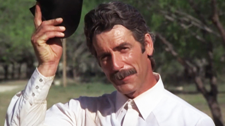 Sam Elliott's Chance McKenzie lifts his hat as he stands outside in The Yellow Rose.jpg