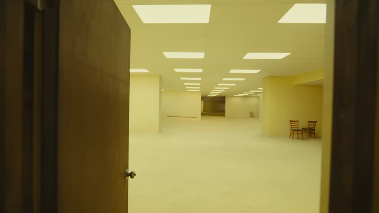 A door opening into a big, winding yellow room in Backrooms