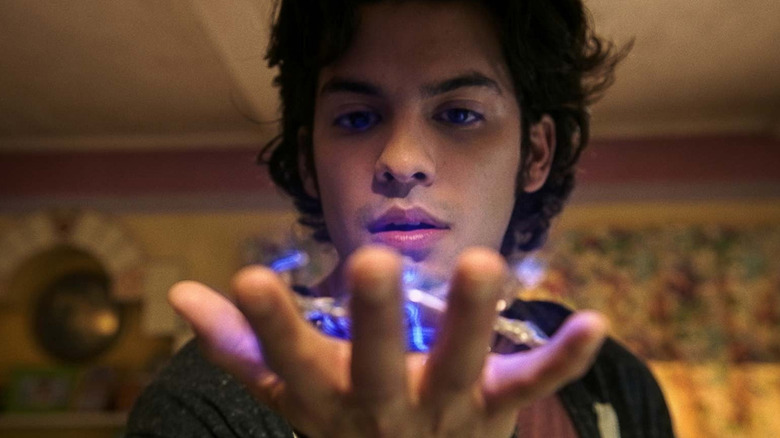 Xolo Maridueña Jaime Reyes holding the scarab in his palm in Blue Beetle