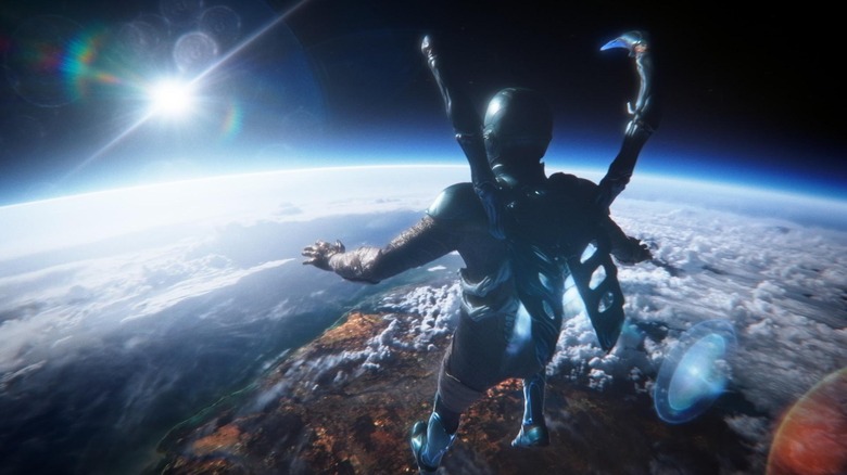 Xolo Maridueña as Blue Beetle hovering above the Earth in Blue Beetle