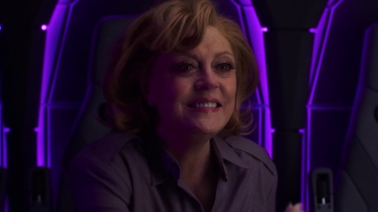 Susan Sarandon as Victoria Kord sitting in a purple lit chair in Blue Beetle
