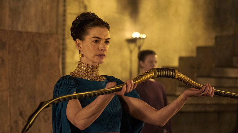 Anne Hathaway as Penelope holding Odysseus' bow in The Odyssey
