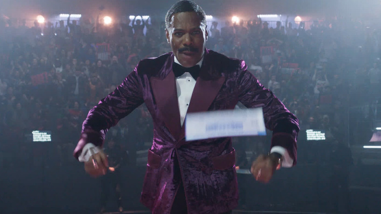 Colman Domingo as Bobby T in his purple jacket hosting the show in The Running Man (2025)