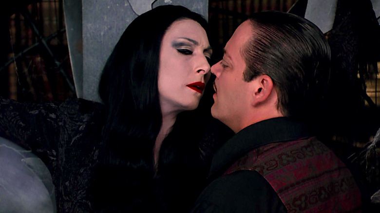 Anjelica Huston and Raul Julia attempt to kiss in The Addams Family