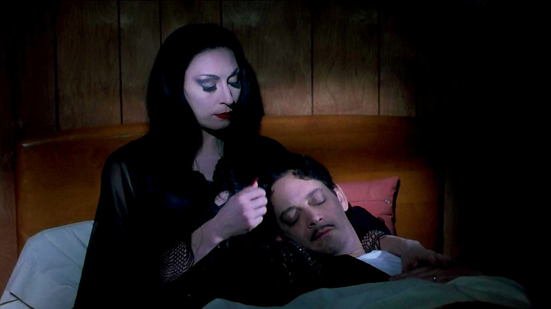 Anjelica Huston and Raul Julia relaxing in bed in The Addams Family