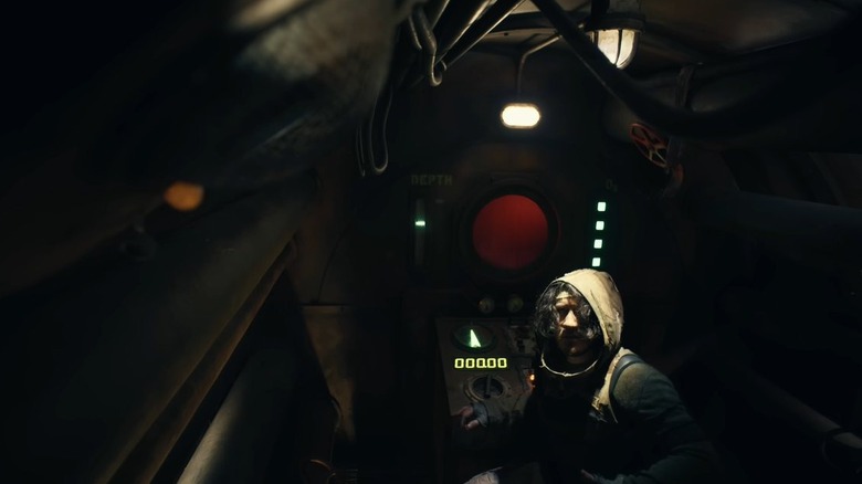 Mark Fischbach as The Convict in his suit sitting at the console of the submarine in Iron Lung