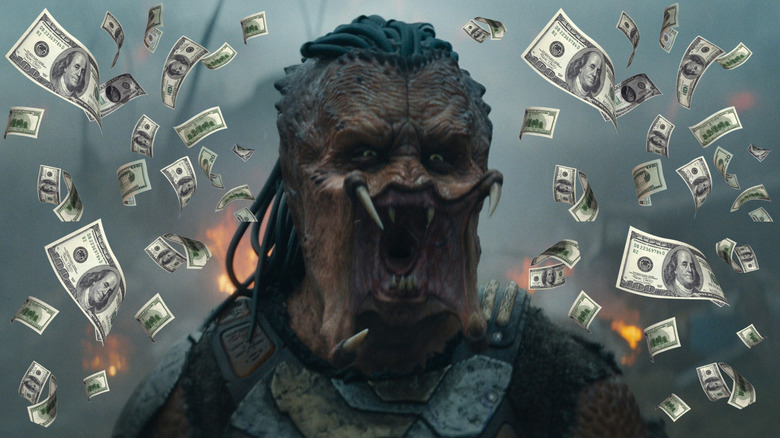 Dek yelling surrounded by money in Predator: Badlands