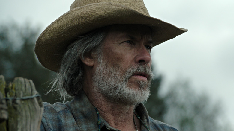 A close up of Guy Pearce as Pops standing by a fence in The Dog Stars
