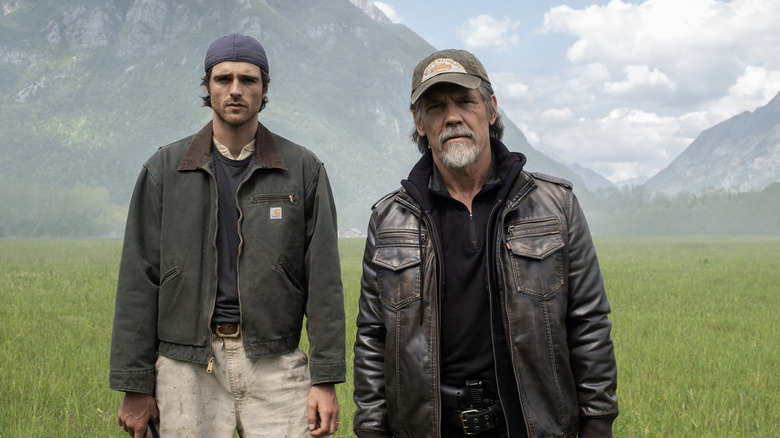 Jacob Elordi as Hig standing next to Josh Brolin as Bangley in a field in The Dog Stars