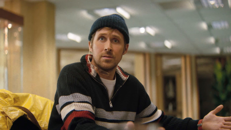 Ryan Gosling as Ryland sitting at a meeting table with a surprised look on his face in Project Hail Mary