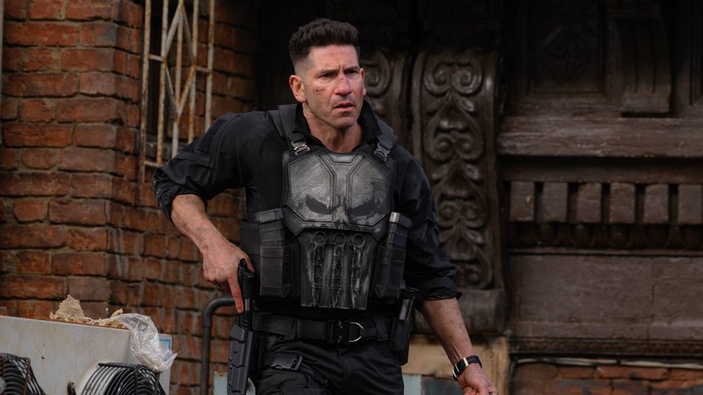 Jon Bernthal as Punisher reaching for his holster and frowning in Spider-Man: Brand New Day