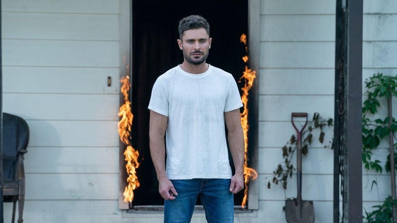 Zac Efron as Andrew standing in front of an on fire dooryway in Firestarter (2022)