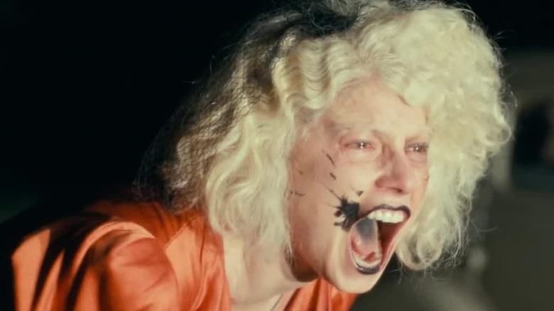 Jessie Buckley as the Bride yelling at night by a car in The Bride!