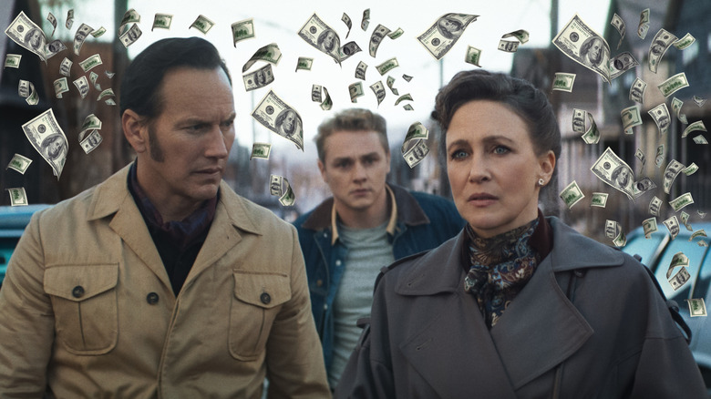 Patrick Wilson and Vera Farmiga as Ed and Lorraine Warren standing in the street surrounded by money in The Conjuring: Last Rites