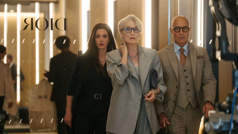 Anne Hathaway as Andy Sachs, Meryl Streep as Miranda Priestly, and Stanley Tucci as Nigel Kipling walking down the hallway in The Devil Wears Prada 2