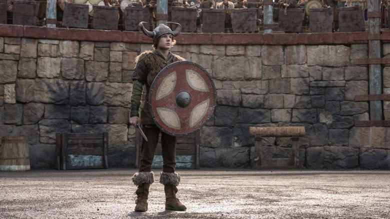 Mason Thames as Hiccup standing in the arena with his shield in How to Train Your Dragon