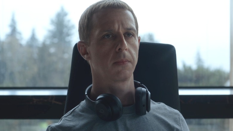 Jeremy Strong as Mark Zuckerbeg sitting at his desk with his headphones around his neck in The Social Reckoning