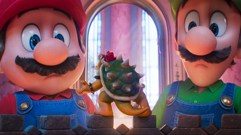 Mario and Luigi looking at tiny Bowser in The Super Mario Galaxy Movie