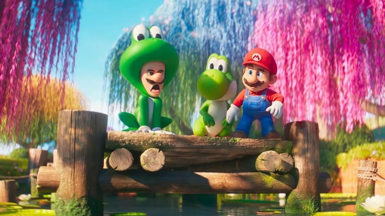 Luigi in his frog costume while Yoshi and Mario look at him in The Super Mario Galaxy Movie